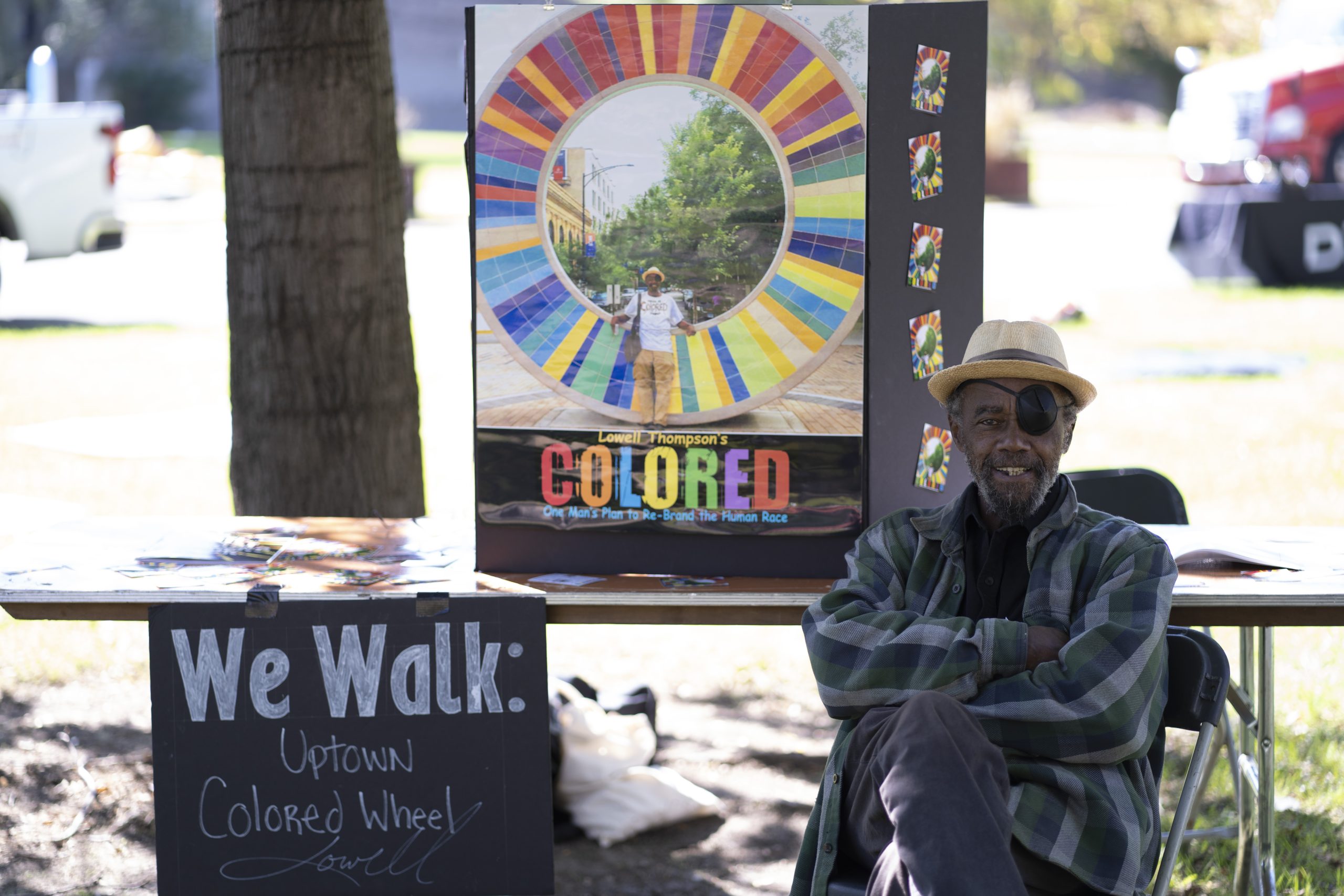 Photo: Artist Lowell Thompson at a previous “We Walk” in front of a poster of his Colored Wheel sculpture, credit Haitian American Museum of Chicago